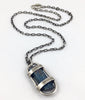 This custom pendant is a raw dark blue Aquamarine stone from Mozambique free floating in a handmade sterling silver cage with a heavy duty sterling silver chain and clasp by Dax Savage Jewelry.